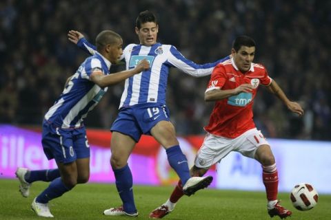 Porto's James (C) and Fernando Reges (L) battles for the ball with Benfica's Maxi Pereira during their Portuguese Cup semi-final soccer match at Dragao stadium in Porto February 2, 2011. REUTERS/Miguel Vidal (PORTUGAL - Tags: SPORT SOCCER)