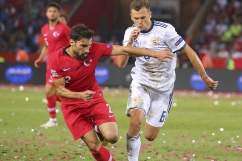 Turkey's Sener Ozbayrakli, left, tries to dribble past Russia's Denis Cheryshev, right, during the UEFA Nations League soccer match between Turkey and Russia in Trabzon, Turkey, Friday, Sept. 7, 2018. (AP Photo)