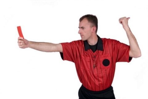 Soccer referee holding red card, and pointing with thumb