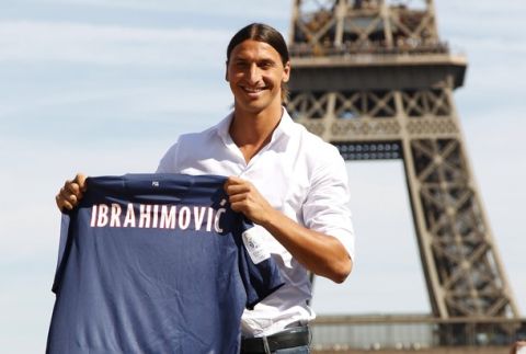 Zlatan Ibrahimovic of Sweden, newly-signed player for French soccer club Paris St Germain, holds his new jersey as he poses at Trocadero square in front of the Eiffel Tower in Paris July 18, 2012. Big-spending Paris St Germain aim to dominate Ligue 1 this season and showed their intent by signing Sweden captain Ibrahimovic from AC Milan on a three-year deal on Wednesday. "Sweden international Zlatan Ibrahimovic, 30, has been transferred from AC Milan and signed a three-year deal in favour of Paris Saint-Germain," PSG said on their website. REUTERS/Charles Platiau (FRANCE - Tags: SPORT SOCCER)