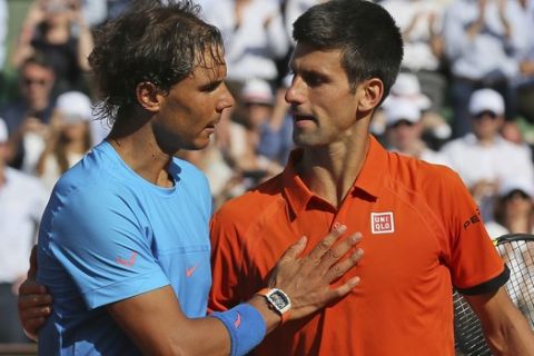 Serbia's Novak Djokovic hugs Spain's Rafael Nadal, left, after winning the quarterfinal match of the French Open tennis tournament in three sets, 7-5, 6-3, 6-1, at the Roland Garros stadium, in Paris, France, Wednesday, June 3, 2015. (AP Photo/David Vincent)