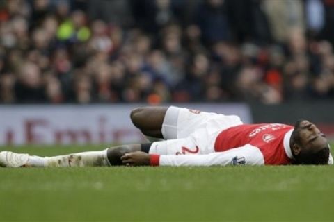 Arsenal's Johan Djourou lies on the ground after a challenge with a Sunderland player during their English Premier League soccer match at Emirates Stadium, London, Saturday, March 5, 2011. (AP Photo/Sang Tan) NO INTERNET/MOBILE USAGE WITHOUT FOOTBALL ASSOCIATION PREMIER LEAGUE (FAPL) LICENCE - CALL +44 (0)20 7864 9121 or EMAIL info@football-dataco.com FOR DETAILS