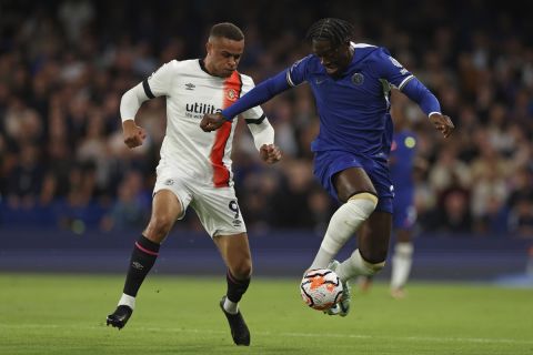 Luton Town's Carlton Morris, left, and Chelsea's Axel Disai vie for the ball during the English Premier League soccer match between Chelsea and Luton Town at Stamford Bridge stadium in London, Saturday, Aug. 26, 2023. (AP Photo/Ian Walton)