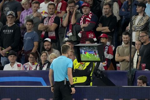 Referee Bartosz Frankowski reviews a possible penalty situation for FC Salzburg during the Champions League group D soccer match between FC Salzburg and Real Sociedad at the Salzburg stadium in Salzburg, Austria, Tuesday, Oct. 3, 2023. (AP Photo/Matthias Schrader)