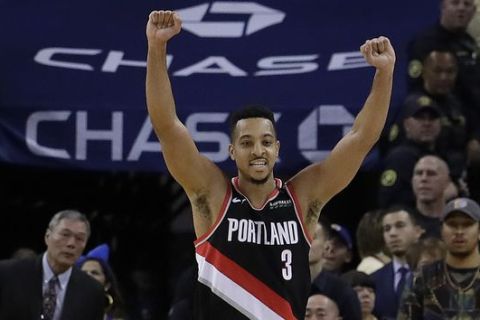 Portland Trail Blazers guard CJ McCollum (3) celebrates as Golden State Warriors forward Kevin Durant lies on his back on the court after missing a shot during overtime of an NBA basketball game in Oakland, Calif., Thursday, Dec. 27, 2018. (AP Photo/Jeff Chiu)