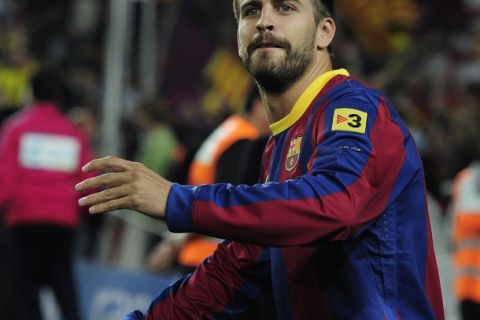 Barcelona's defender Gerard Pique throws red pepper to Barcelona's supporters after the team won the Spanish league title after the football match between FC Barcelona vs RC Deportivo de la Coruna at the Camp Nou stadium in Barcelona on May 15, 2011.    AFP PHOTO/ JOSEP LAGO (Photo credit should read JOSEP LAGO/AFP/Getty Images)