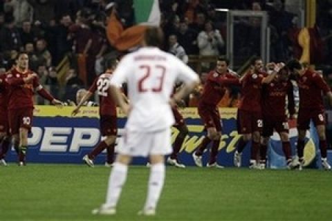 Milan's Massimo Ambrosini, center, looks on as AS Roma's players celebrate after their teammate Mirko Vucinic of Montenegro scored during the Italian Serie A top league soccer match between AS Roma and Milan, in Rome's Olympic stadium, Saturday, March, 15, 2008. (AP Photo/Andrew Medichini)