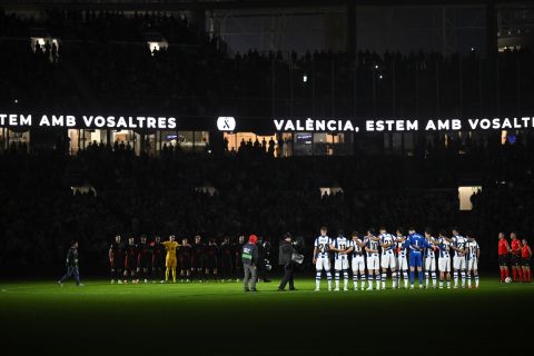 Teams stand for a moment of silence in memory of the flood victims in Valencia, before the Spanish La Liga soccer match between Real Sociedad and Barcelona at the Anoeta stadium, in San Sebastian, Spain, Sunday, Nov. 10, 2024. (AP Photo/Miguel Oses)