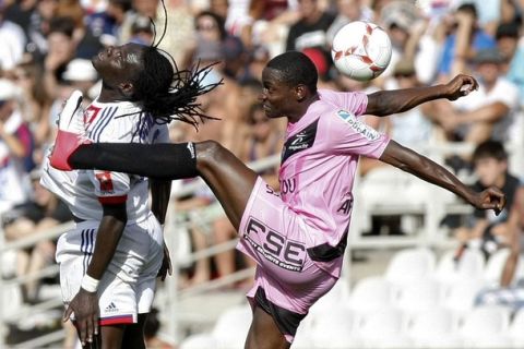 Olympique Lyon's Bafetimbi Gomis (L) challenges Granddi Ngoyi (R) of Troyes during their French Ligue 1 soccer match at the Gerland stadium in Lyon August 18, 2012. REUTERS/Emmanuel Foudrot (FRANCE - Tags: SPORT SOCCER)