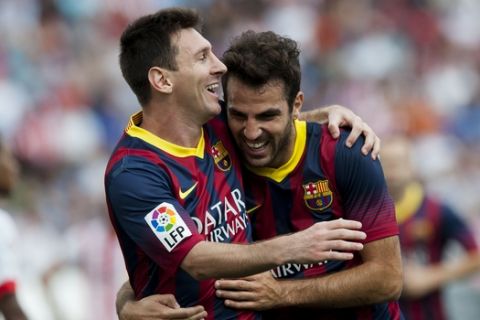 FC Barcelona's Lionel Messi, from Argentina, left, celebrates with teammate Cesc Fabregas, after scoring a goal against Almeria during a Spanish La Liga soccer match in Almeria, Spain, Saturday, Sept. 28, 2013. (AP Photo/Daniel Tejedor)