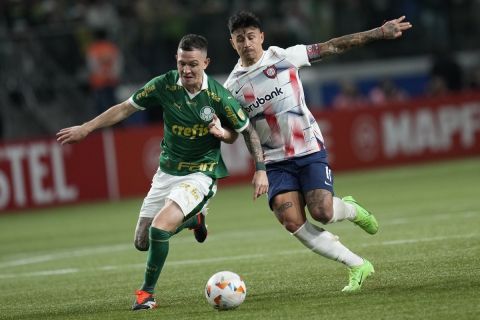 Anibal Moreno of Brazil's Palmeiras, left, and Adam Bareiro of Argentina's San Lorenzo battle for the ball during a Copa Libertadores Group F soccer match at Allianz Parque stadium in Sao Paulo, Brazil, Thursday, May 30, 2024. (AP Photo/Andre Penner)