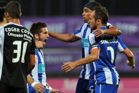 FC Porto's Joao Moutinho, center, Alvaro Pereira, from Uruguay, and Fernando Belluschi, right, from Argentina, react after their first goal against Nacional during their Portuguese League soccer game in the Portuguese island of Madeira, Monday, Sept. 20, 2010.  (AP Photo/Helder Santos)