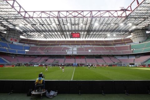 FILE - In this Sunday, March 8, 2020 filer, a view of the empty stadium during the Serie A soccer match between AC Milan and Genoa at the San Siro stadium, in Milan, Italy. While soccer leagues around Europe are still debating whether and when to resume playing, the leader of the continents Federation of Sports Medicine Associations is calling for a detailed series of tests to clear athletes for a return to training. Maurizio Casasco, who is also president of the Italian Federation of Sports Medicine, said that guidelines recently published by his domestic federation should be extended for all of Europe -- especially if UEFA intends to resume the Champions League and Europa League anytime soon. (AP Photo/Antonio Calanni, File)