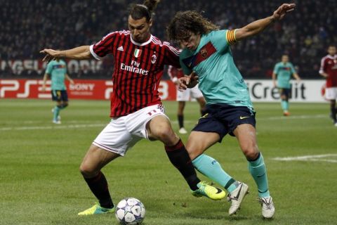 AC Milan's Zlatan Ibrahimovic (L) challenges Carles Puyol of Barcelona during their Champions League Group H soccer match at San Siro stadium in Milan November 23, 2011.  REUTERS/Stefano Rellandini  (ITALY - Tags: SPORT SOCCER)