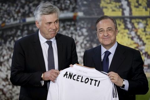 Real Madrid's new coach Carlo Ancelotti, left, and Real Madrid's President Florentino Perez display a shirt bearing the name of the new coach,  during his presentation, in Madrid, Wednesday, June 26, 2013. Real Madrid has presented new coach Carlo Ancelotti as "a true sage" of football. Ancelotti was introduced to Madrid members and the press at the Santiago Bernabeu by club president Florentino Perez on Wednesday in a step aimed at healing the rifts caused by predecessor Jose Mourinho. (AP Photo/Daniel Ochoa de Olza)