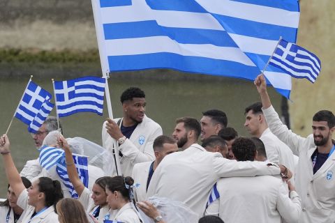 The boat carrying team Greece, with basketball player Giannis Antetokounmpo, center back, makes its way down the Seine in Paris, France, during the opening ceremony of the 2024 Summer Olympics, Friday, July 26, 2024. (AP Photo/Rebecca Blackwell)