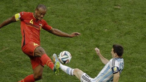 Belgium's Vincent Kompany, left,  and Argentina's Lionel Messi fight for the ball during the World Cup quarterfinal soccer match between Argentina and Belgium at the Estadio Nacional in Brasilia, Brazil, Saturday, July 5, 2014. (AP Photo/Thanassis Stavrakis)