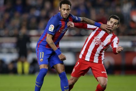 FC Barcelona's Neymar, left, duels for the ball against Sporting Gijon's Victor Rodriguez during the Spanish La Liga soccer match between FC Barcelona and Sporting Gijon at the Camp Nou stadium in Barcelona, Spain, Wednesday, March 1, 2017. (AP Photo/Manu Fernandez)