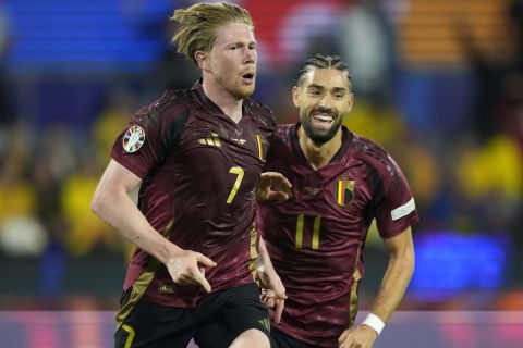 Belgium's Kevin De Bruyne, left, celebrates with Belgium's Yannick Carrasco after scoring his side's second goal during a Group E match between Belgium and Romania at the Euro 2024 soccer tournament in Cologne, Germany, Saturday, June 22, 2024. (AP Photo/Martin Meissner)