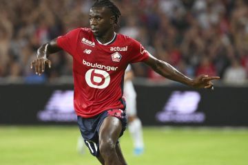 Lille's Ngal'ayel Mukau runs with the ball watched by PSG's Warren Zaire-Emery, left, during the French League 1 soccer match between Lille and Paris Saint-Germain, in Villeneuve-d'Ascq, France, Sunday, Sept. 1, 2024. (AP Photo/Matthieu Mirville)