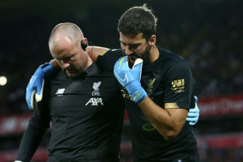 Liverpool's goalkeeper Alisson Becker, right, reacts as he leaves the pitch after an injury during the English Premier League soccer match between Liverpool and Norwich City at Anfield in Liverpool, England, Friday, Aug. 9, 2019. (AP Photo/Dave Thompson)