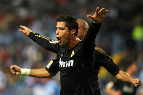 Real Madrid's Portuguese forward Cristiano Ronaldo celebrates after scoring during the Spanish league football match Malaga CF vs Real Madrid on October 22, 2011 at Rosaleda stadium in Malaga.    AFP PHOTO/ JORGE GUERRERO (Photo credit should read Jorge Guerrero/AFP/Getty Images)