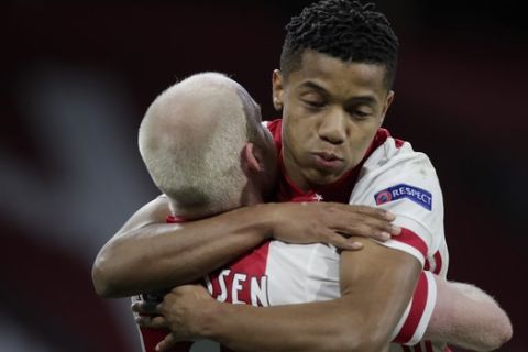 Ajax's David Neres, right, celebrates with teammate Davy Klaassen after Klaassen scored his side's first goal during the Europa League round of 16 first leg soccer match between Ajax and Young Boys at the Johan Cruyff ArenA in Amsterdam, Netherlands, Thursday, March 11, 2021. (AP Photo/Peter Dejong)