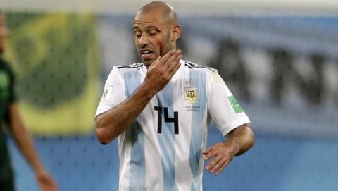 Argentina's Javier Mascherano touches his face after an injuring during the group D match between Argentina and Nigeria, at the 2018 soccer World Cup in the St. Petersburg Stadium in St. Petersburg, Russia, Tuesday, June 26, 2018. (AP Photo/Petr David Josek)