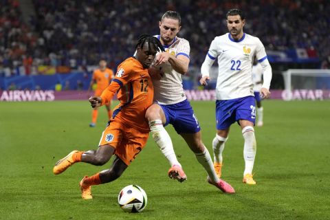 Jeremie Frimpong of the Netherlands, left, vies for the ball with Adrien Rabiot of France during a Group D match between the Netherlands and France at the Euro 2024 soccer tournament in Leipzig, Germany, Friday, June 21, 2024. (AP Photo/Mathias Schrader)