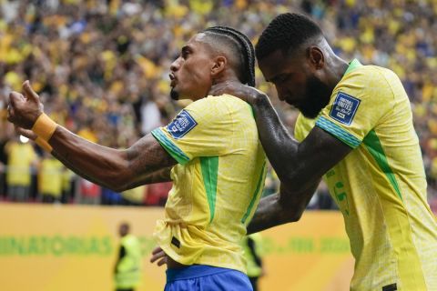 Brazil's Raphinha, left, celebrates after scoring his side's second goal from the penalty spot against Peru during a qualifying soccer match for the FIFA World Cup 2026 at Mane Garrincha Stadium in Brasilia, Brazil, Tuesday, Oct. 15, 2024. (AP Photo/Eraldo Peres)