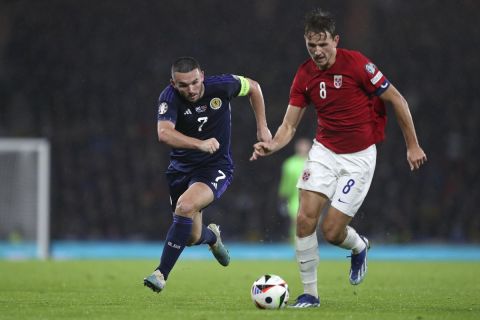 John McGinn of Scotland chases Sander Berge of Norway during the Euro 2024 group A soccer match between Scotland and Norway at Hampden Park in Glasgow, Scotland, Sunday, Nov. 19, 2023. (AP Photo/Scott Heppell)