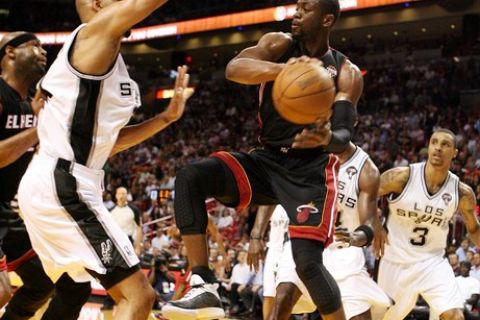 MIAMI - MARCH 14:  Guard Dwyane Wade #3 of the Miami Heat passes  against Center Tim Duncan #21 of the San Antonio Spurs at American Airlines Arena on March 14, 2011 in Miami, Florida. NOTE TO USER: User expressly acknowledges and agrees that, by downloading and/or using this Photograph, User is consenting to the terms and conditions of the Getty Images License Agreement.  (Photo by Marc Serota/Getty Images)