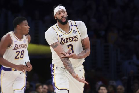 Los Angeles Lakers forward Anthony Davis (3) gestures after making a three-point basket as Memphis Grizzlies forward Jaren Jackson Jr. looks away during the first half of an NBA basketball game, Sunday, Dec. 15, 2024, in Los Angeles. (AP Photo/Jessie Alcheh)