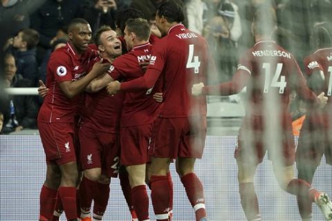 Liverpool players celebrate after Divock Origi, obscured, scored their third goal against Newcastle United during the Premier League soccer match at St James' Park, in Newcastle, England, Saturday May 4, 2019. (Owen Humphreys/PA via AP)