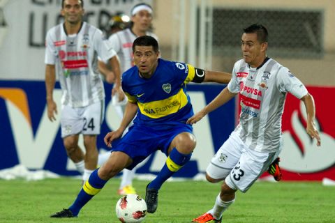 Engelberth Briceno (R) of Zamora FC vies for the ball with Juan Roman Riquelme (L) of Boca Juniors during their 2012 Libertadores Cup football match at Carolina Stadium in Barinas, Venezuela on February 14, 2012. AFP PHOTO/JUAN BARRETO (Photo credit should read JUAN BARRETO/AFP/Getty Images)