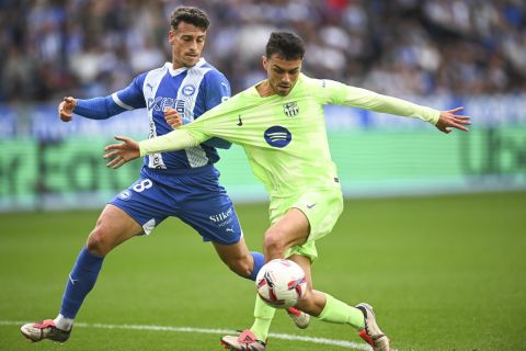 Barcelona's Pedri, front, and Alaves' Antonio Blanco fight for the ball during a Spanish La Liga soccer match at the Mendizorroza stadium in Vitoria-Gasteiz, Spain, Sunday, Oct. 6, 2024. (AP Photo/Miguel Oses)