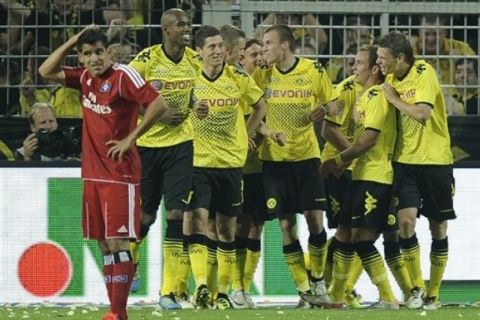 Dortmund's Kevin Grosskreutz, center, celebrates with his team after he scored the third goal during the German first division Bundesliga soccer match between Borussia Dortmund and Hamburg SV in Dortmund, Germany, Friday, Aug. 5, 2011. Champion Dortmund plays traditionally the opening match of the new season. (AP Photo/Martin Meissner) ** NO MOBILE USE UNTIL 2 HOURS AFTER THE MATCH, WEBSITE USERS ARE OBLIGED TO COMPLY WITH DFL-RESTRICTIONS, SEE INSTRUCTIONS FOR DETAILS **