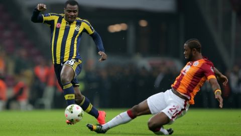 Galatasaray's Aurelien Chedjou, right, and Emmanuel Emenike of Fenerbahce fight for the ball during their Turkish League soccer derby match at the TT Arena stadium in Istanbul, Turkey, Saturday, Oct. 18, 2014.(AP Photo)