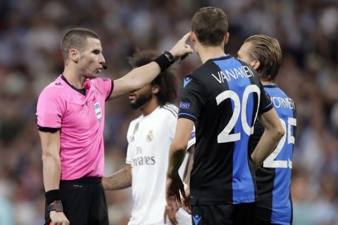 Brugge's Ruud Vormer, right, gets a red card by referee Georgi Kabakov during the Champions League group A soccer match between Real Madrid and Club Brugge, at the Santiago Bernabeu stadium in Madrid, Tuesday, Oct.1, 2019. (AP Photo/Manu Fernandez)