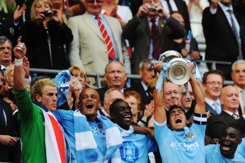 LONDON, ENGLAND - MAY 14:  Carlos Tevez lifts the trophy after he and his Manchester City team mates win the FA Cup sponsored by E.ON Final match between Manchester City and Stoke City at Wembley Stadium on May 14, 2011 in London, England.  (Photo by Mike Hewitt/Getty Images)