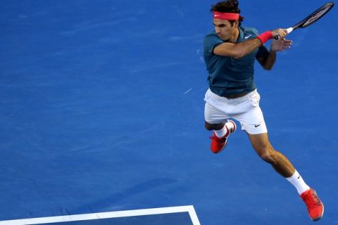 Roger Federer of Switzerland leaps for a shot to Andy Murray of Britain during their quarterfinal at the Australian Open tennis championship in Melbourne, Australia, Wednesday, Jan. 22, 2014. (AP Photo/Eugene Hoshiko)