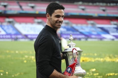 Arsenal's head coach Mikel Arteta celebrates with the trophy during the presentation for the FA Cup final soccer match between Arsenal and Chelsea at Wembley stadium in London, England, Saturday, Aug. 1, 2020. Arsenal won the match 2-1. (Adam Davy/Pool via AP)