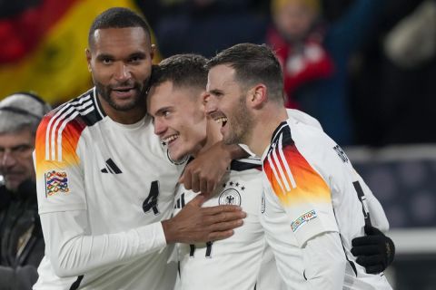 Germany's Florian Wirtz, center, celebrates with Jonathan Tah, left, after scoring his side's fourth goal during the Nations League group soccer match between Germany and Bosnia in Freiburg, Germany, Saturday, Nov. 16, 2024. (AP Photo/Michael Probst)