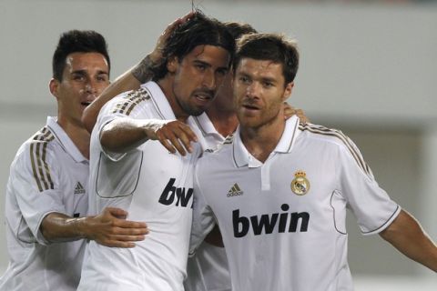 Real Madrid's Sami Khedira (2nd L) celebrates a goal with team-mate Xabi Alonso (R) during their friendly soccer match against Guangzhou Evergrande at Tiahe Stadium in Guangzhou, Guangdong province August 3, 2011. REUTERS/Tyrone Siu (CHINA - Tags: SPORT SOCCER)