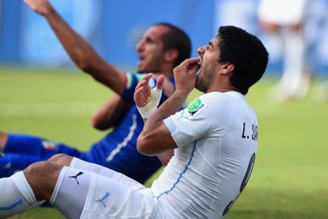 NATAL, BRAZIL - JUNE 24:  Luis Suarez of Uruguay and Giorgio Chiellini of Italy react after a clash during the 2014 FIFA World Cup Brazil Group D match between Italy and Uruguay at Estadio das Dunas on June 24, 2014 in Natal, Brazil.  (Photo by Matthias Hangst/Getty Images)