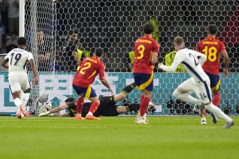 England's Cole Palmer, right, scores his side's first goal as Spain's goalkeeper Unai Simon tries to save during the final match between Spain and England at the Euro 2024 soccer tournament in Berlin, Germany, Sunday, July 14, 2024. (AP Photo/Matthias Schrader)