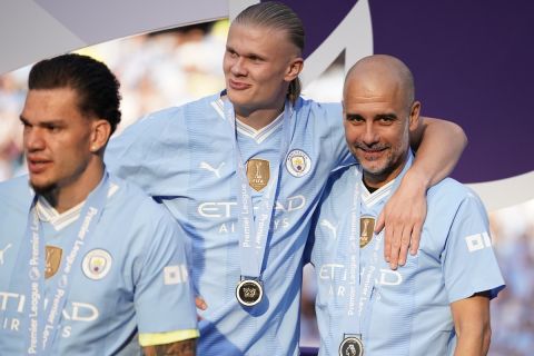 Manchester City's head coach Pep Guardiola, right, celebrates with Manchester City's Erling Haaland at the end of the English Premier League soccer match between Manchester City and West Ham United at the Etihad Stadium in Manchester, England, Sunday, May 19, 2024. Manchester City clinched the English Premier League on Sunday after beating West Ham in their last match of the season. (AP Photo/Dave Thompson)