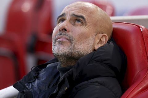 Manchester City's head coach Pep Guardiola sits on the bench before the English Premier League soccer match between Liverpool and Manchester City at Anfield Stadium, Liverpool, England, Sunday Dec. 1, 2024. (AP Photo/Ian Hodgson)