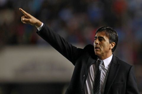 Gustavo Quinteros, coach of Ecuador's Emelec, gives instructions to his players on the sidelines of a Copa Libertadores soccer match against Bolivia's Bolivar in La Paz, Bolivia, Wednesday, April 9, 2014. (AP Photo/Juan Karita)