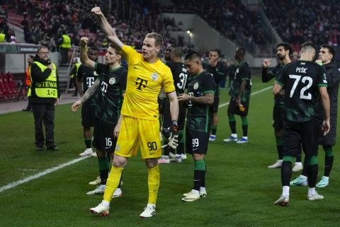 Ferencvaros players greet their supporters at the end of the Europa Conference League knockout round play-offs game between Olympiacos and Ferencvaros at Georgios Karaiskakis stadium at Piraeus port, near Athens, Thursday, Feb. 15, 2024. (AP Photo/Thanassis Stavrakis)